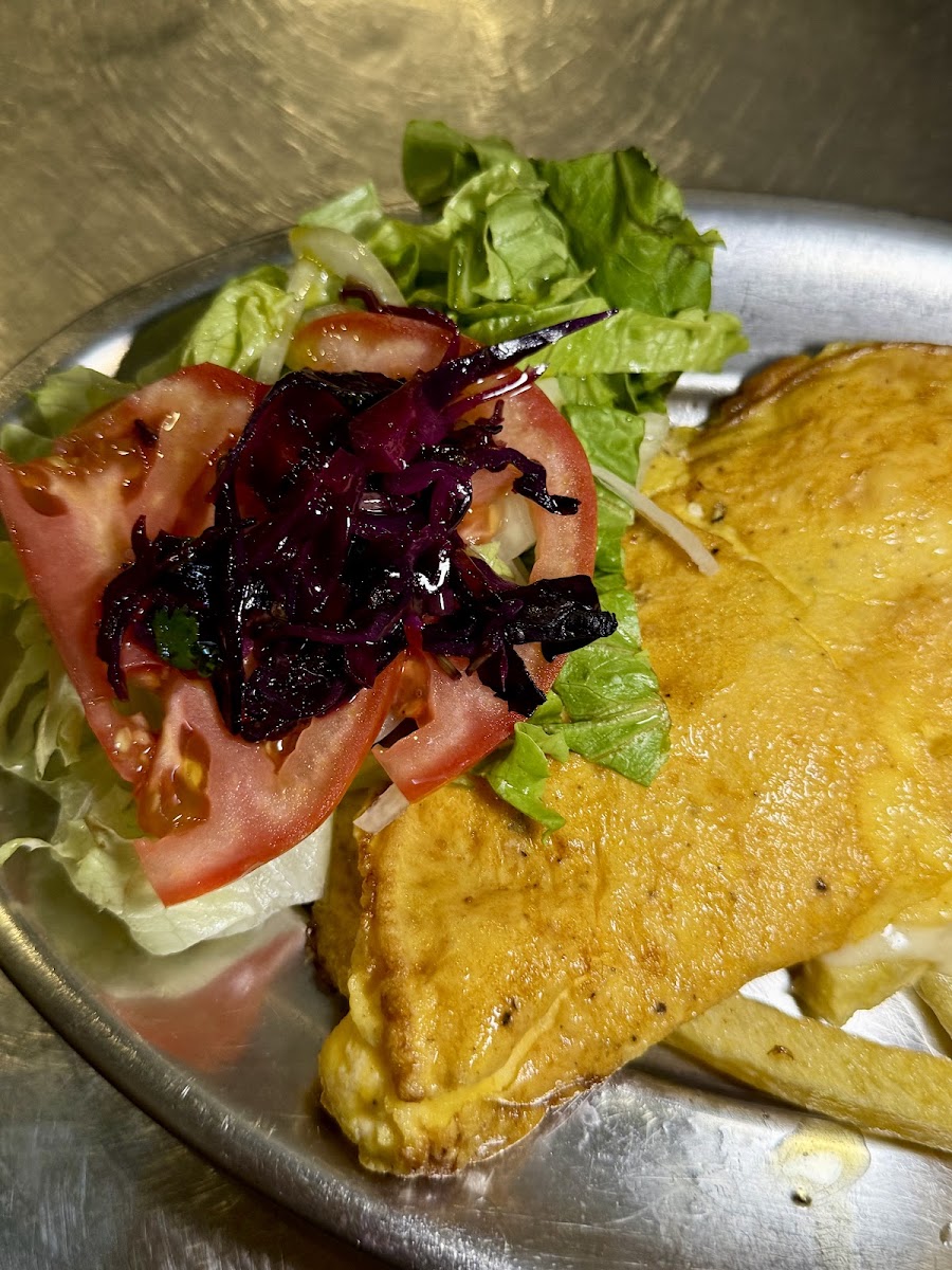 Prato de metal com panado, batata frita, alface e tomate às rodelas
